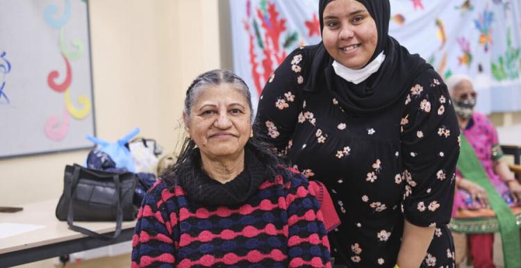 Image of one person caring for another.  